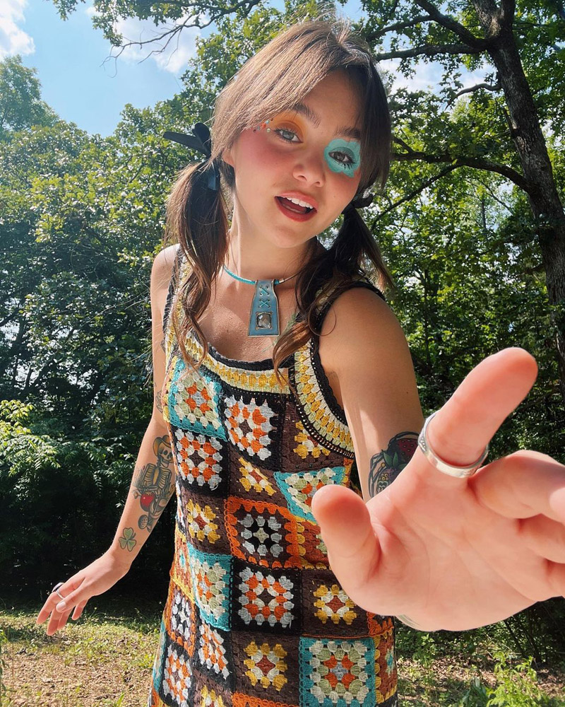 Customer @angelima_bean wearing a colorful crochet A-line dress, chunky silver necklace, and black bows in their hair. Customer @angelima_bean wearing a colorful crochet A-line dress, chunky silver necklace, and black bows in their hair