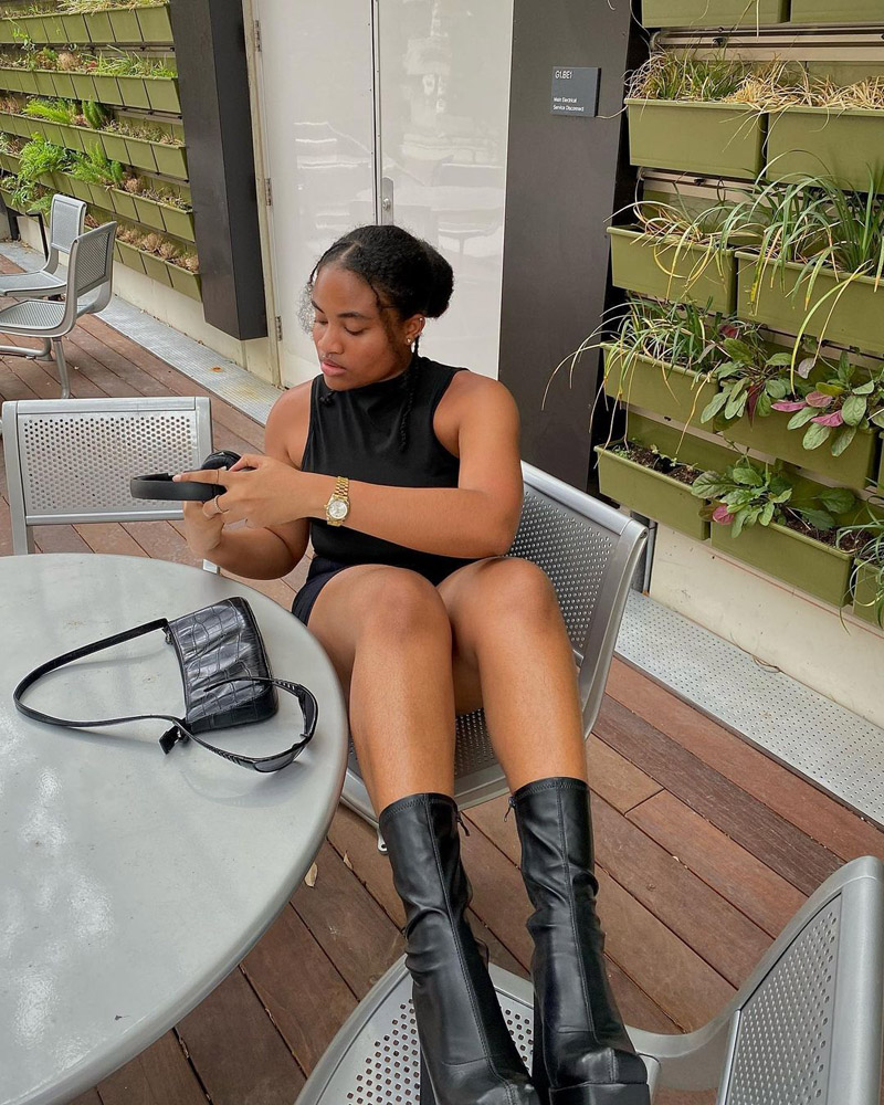 Customer @dianeaudrey.ak wearing a black dress, chunky ankle boots, a leather croc-effect shoulder bag, and a gold watch. Customer @dianeaudrey.ak wearing a black dress, chunky ankle boots, a leather croc-effect shoulder bag, and a gold watch.